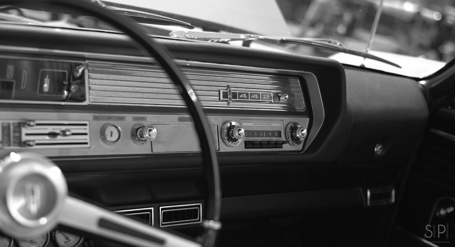 Black and white photo of a classic car dashboard.